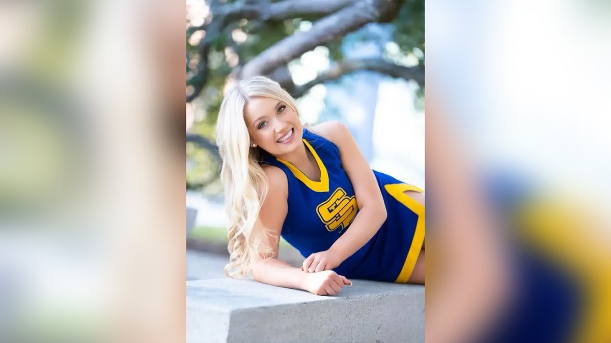 Madison Brooks posing for a photo in her cheerleader uniform.