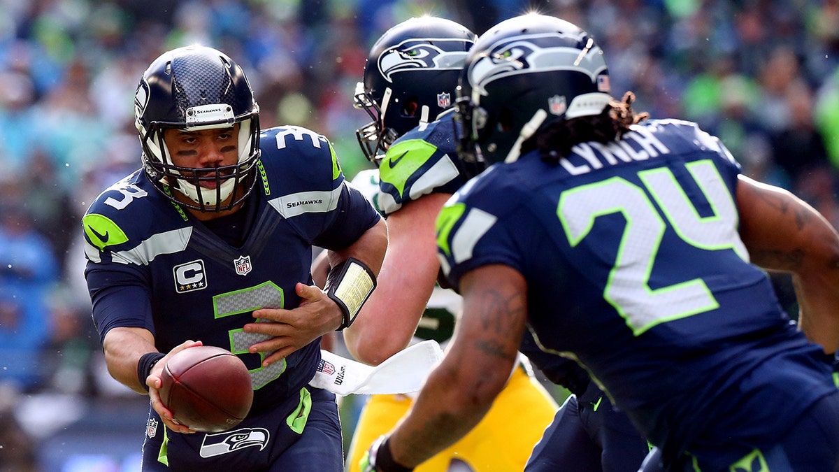 Russell Wilson hands the football to Marshawn Lynch