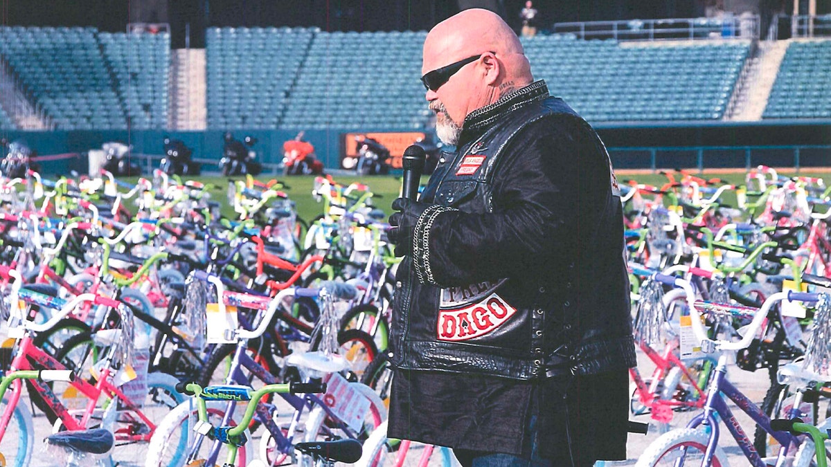 Merl Hefferman stands among bike donations in Hells Angels vest