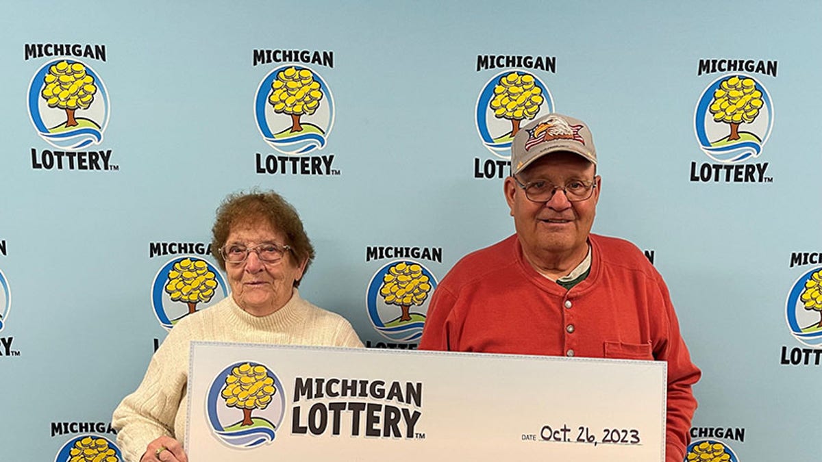 Charles Wolthuis (right) and his wife Jean Wolthuis (left) holding $1 million check. (Credit: Michigan Lottery)