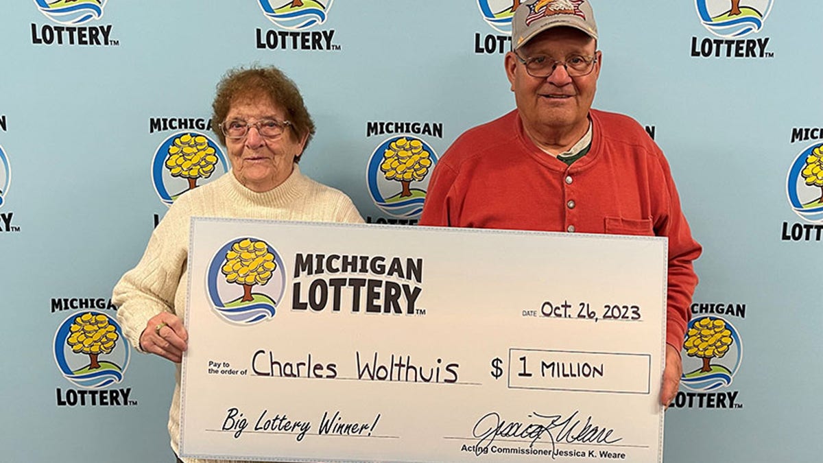 Charles Wolthuis (right) and his wife Jean Wolthuis (left) holding $1 million check. (Credit: Michigan Lottery)
