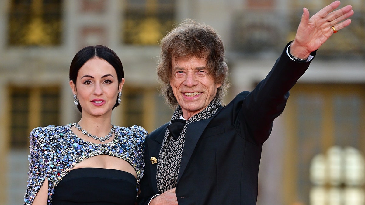 Mick Jagger waving with Melanie Hamrick