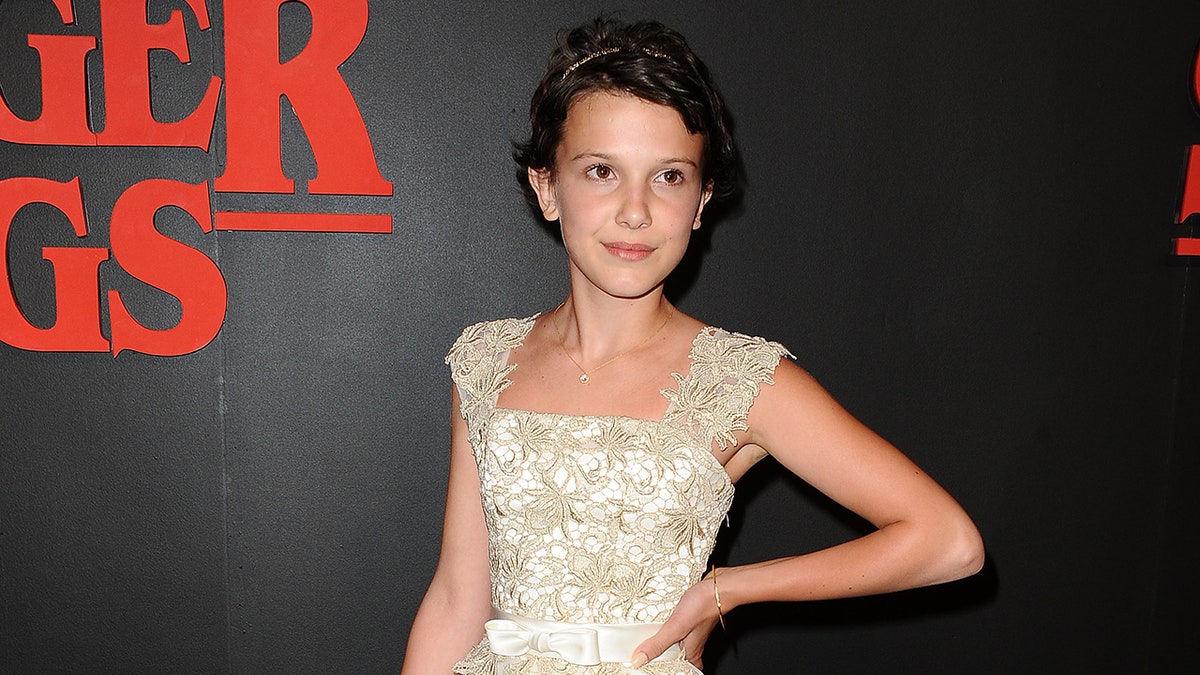 Millie Bobby Brown posing as a 12-year-old on the Stranger Things red carpet