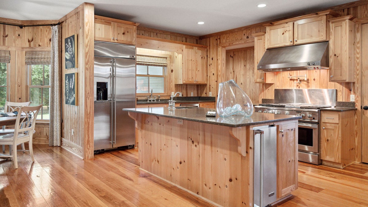 Pine floors and cabinets and stainless alloy  appliances successful  the Murdaugh kitchen.