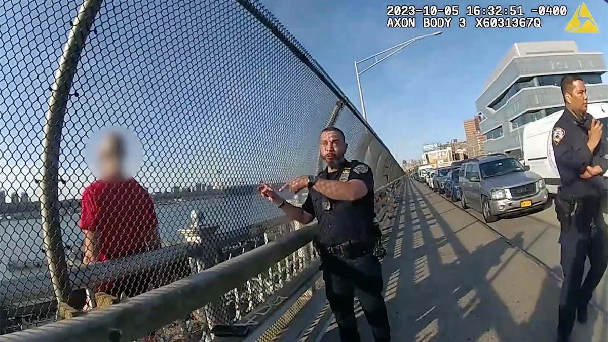 NYPD Officer Eleodoro Mata gestures on other side of fence from suicidal man