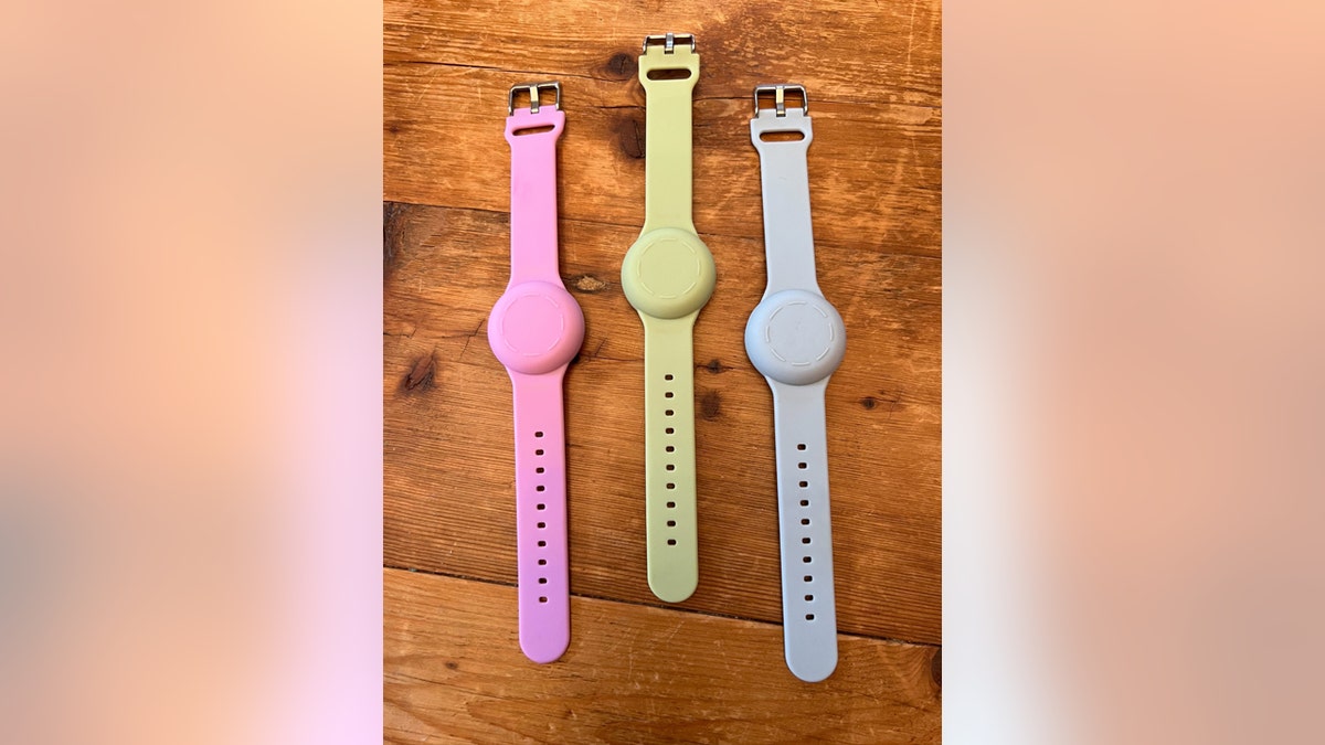 Three Apple AirTag watch bands: Pink, yellow and gray.