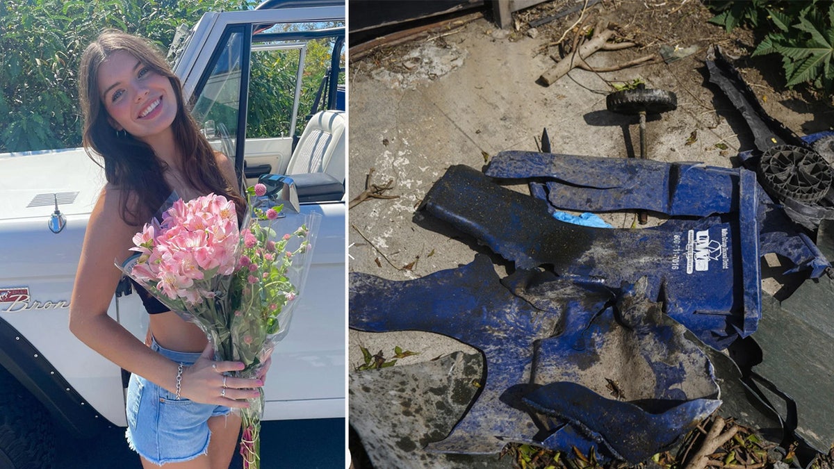 A woman holds a bouquet of roses next to a splintered trash can.
