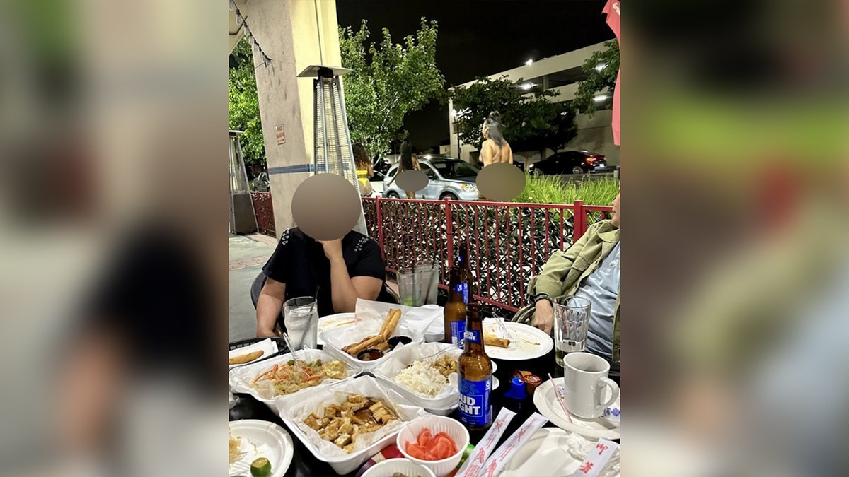 family eating dinner while alleged prostitute walks by in background