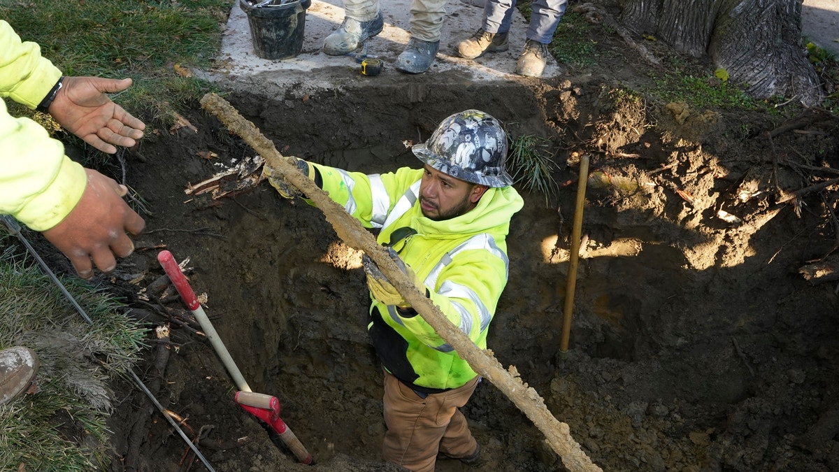 A pipe is pulled from a dig site at a Michigan home