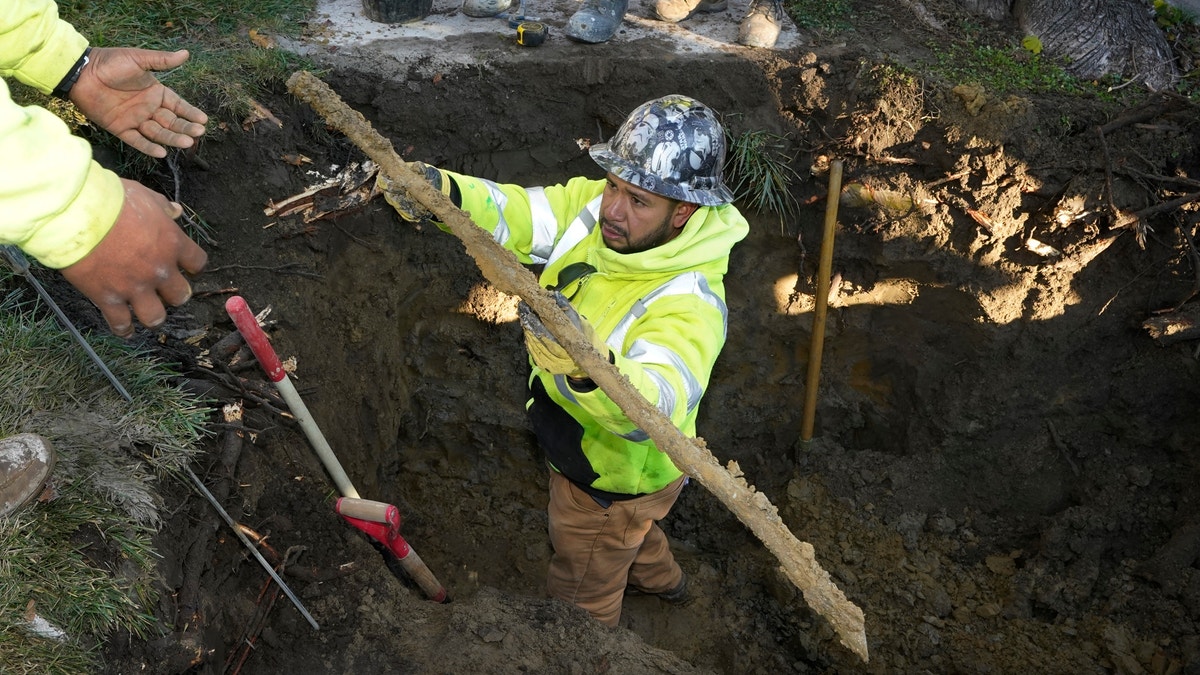 A pipe is pulled from a dig site at a Michigan home