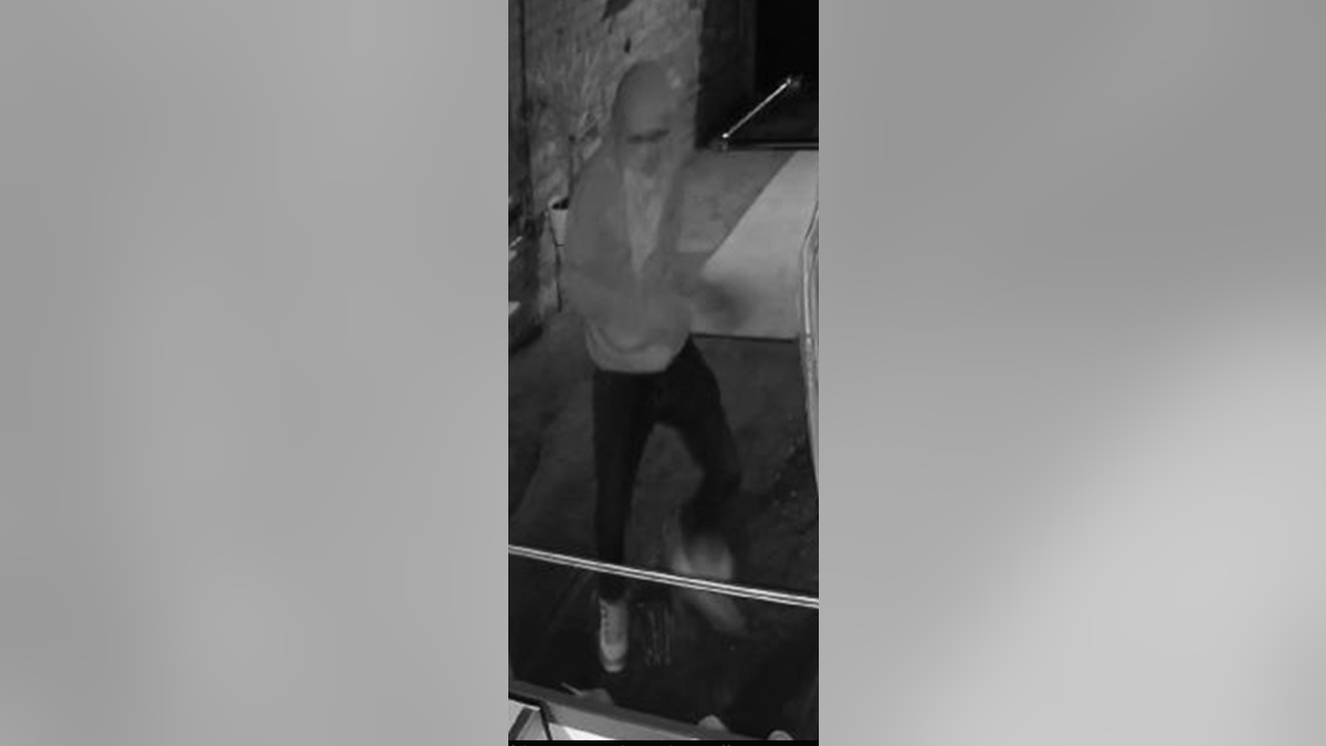 suspect in store robbery in black/white surveillance photo