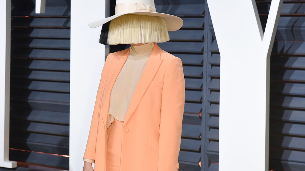 Sia wearing a face covering wig on the red carpet