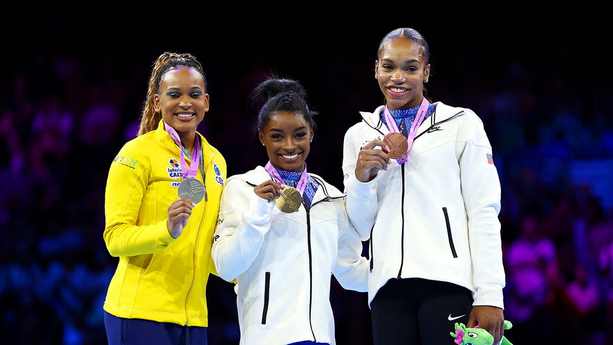 Gymnasts pose during a medal ceremony 