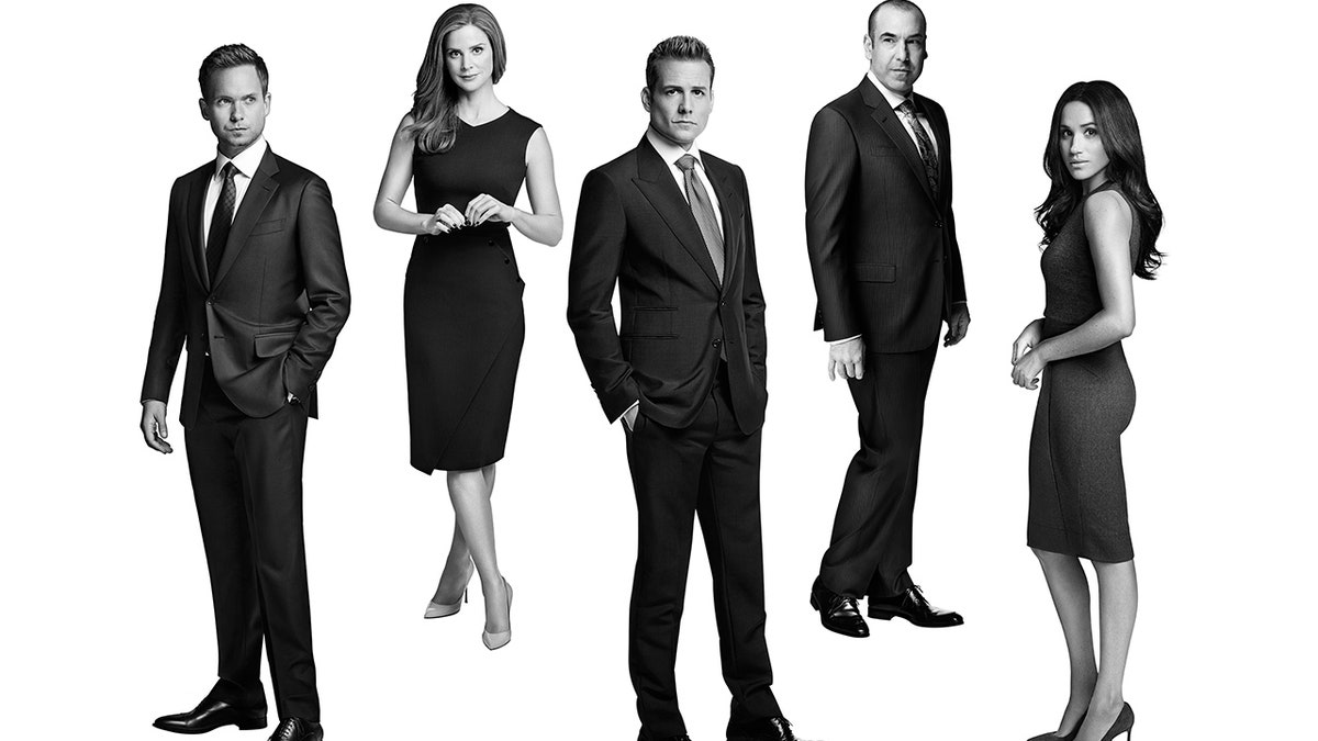 Black and white photo of the cast of Suits, including Meghan Markle, far right