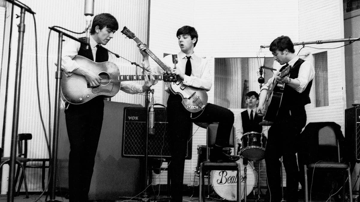 Black and white photo of The Beatles in a studio together