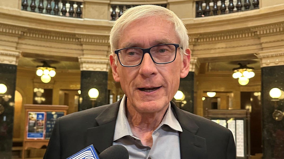 Tony Evers speaks with reporters