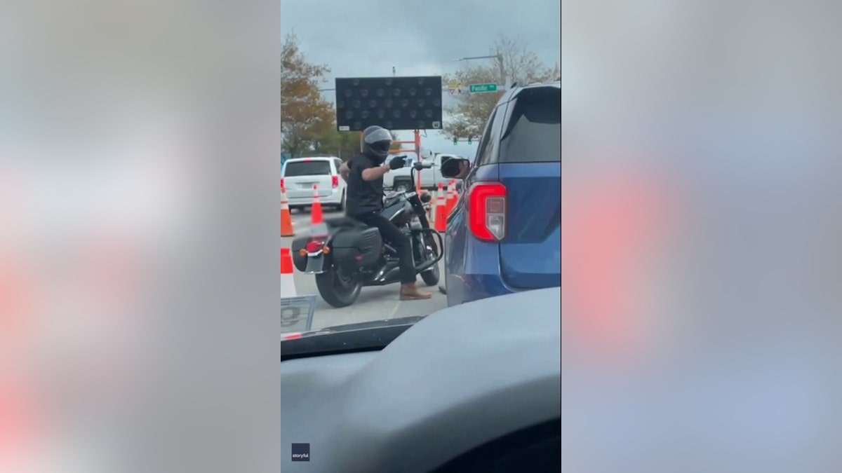 motorcyclist pointing at driver