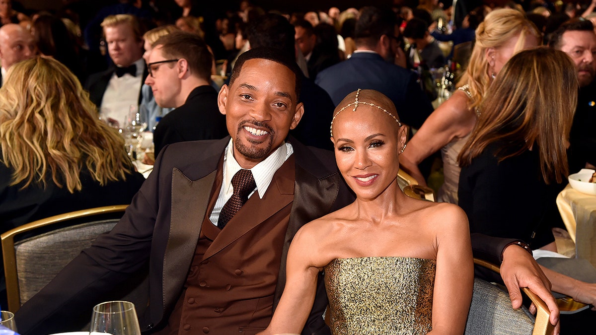 Will Smith and Jada Pinkett Smith sitting at a table together.