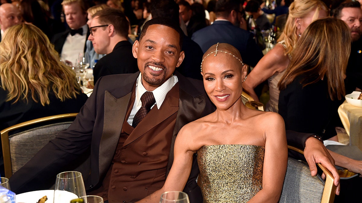 Will Smith and Jada Pinkett Smith sitting at a table together.