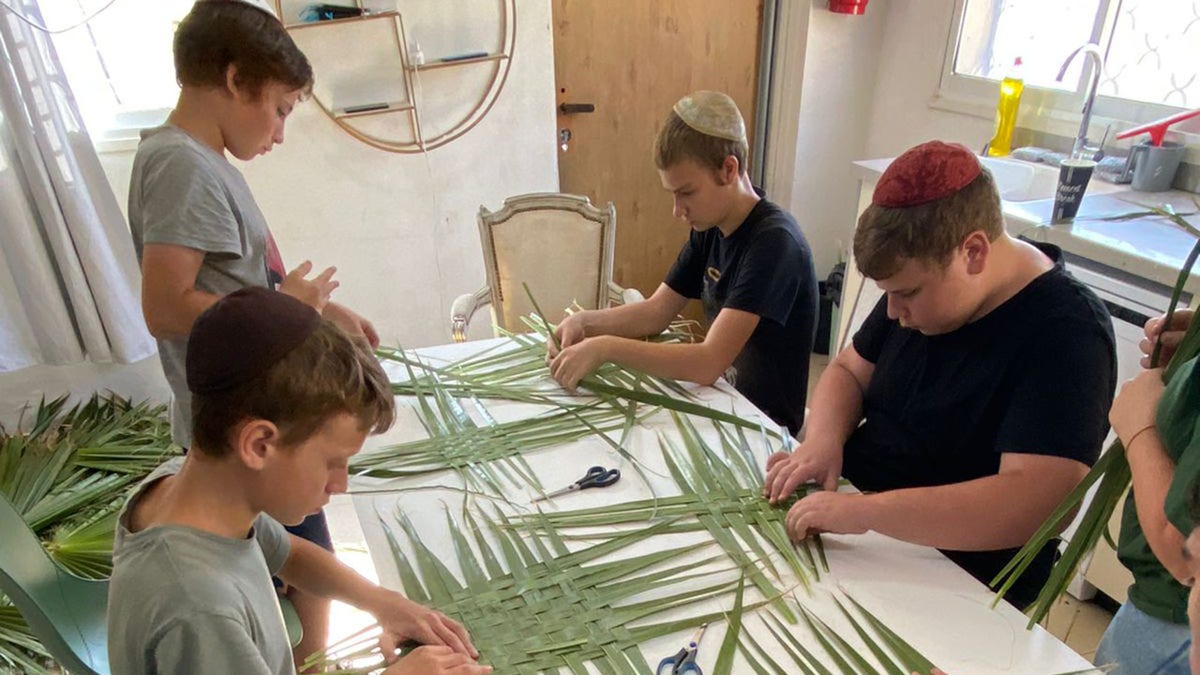 boys weaving plant leaves, craft, activity