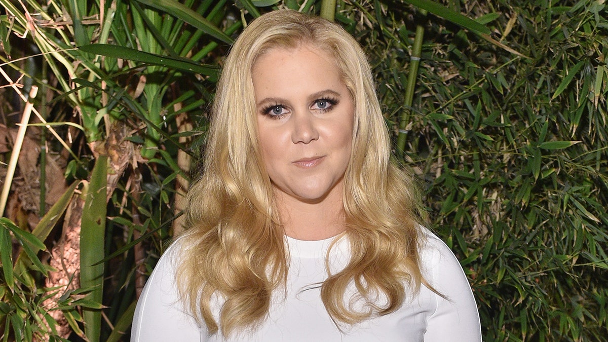 Amy Schumer attends red carpet screening wearing white dress