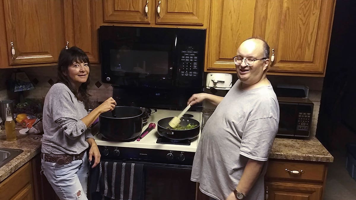 Anthony Talotta and his cousin's wife in kitchen cooking