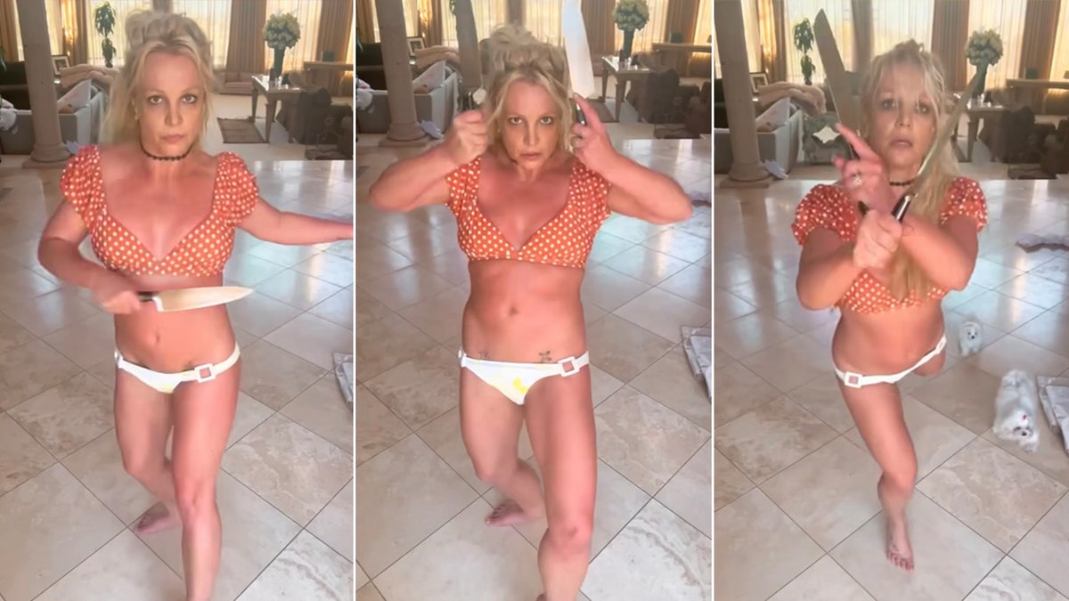 Britney Spears in an orange polka dot bikini and white bottoms dances with knives
