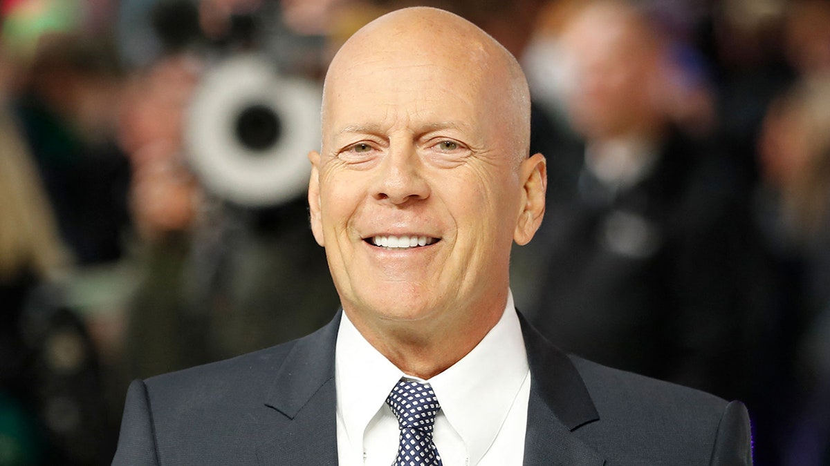 Bruce Willis looks directly at the camera on the carpet in London