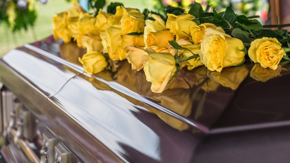 a casket with flowers connected  it