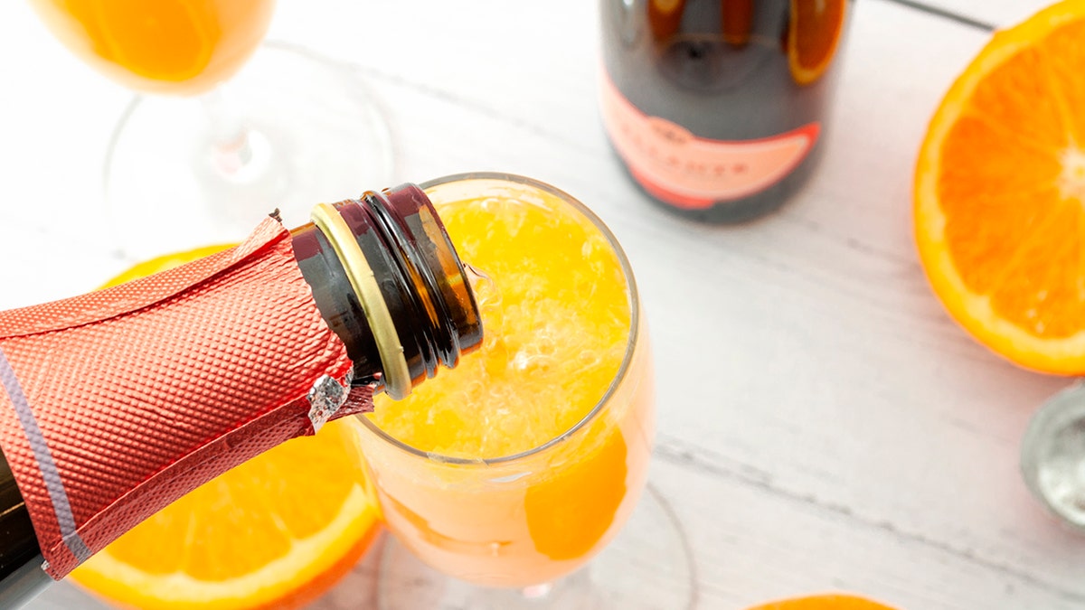 Derramando champanhe em taça de mimosa