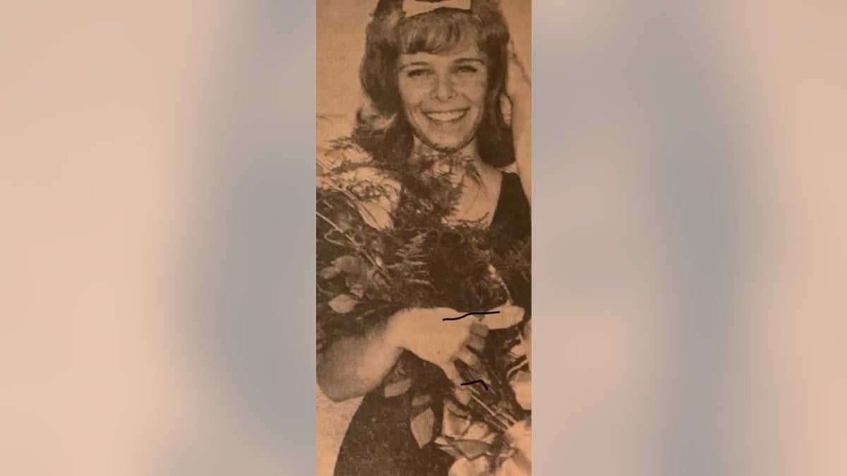 Noelle Russo pictured holding flowers and smiling 