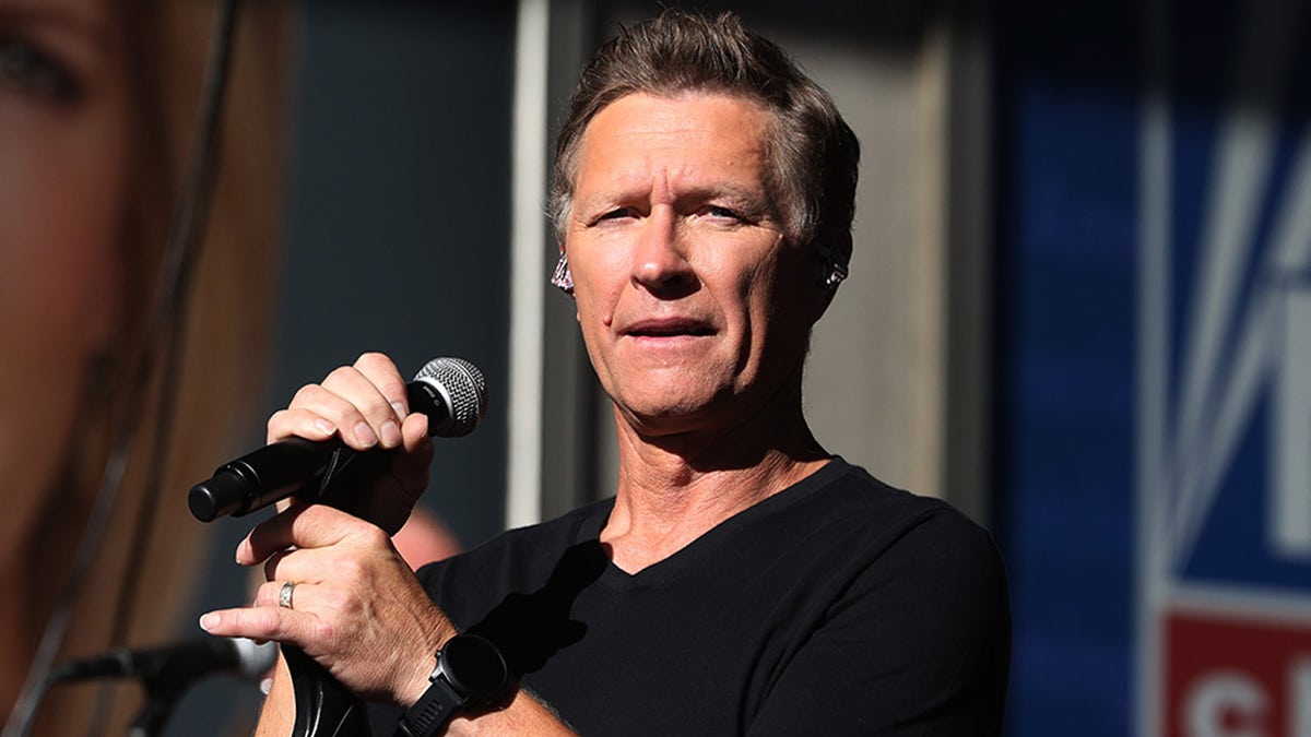 Craig Morgan holds a microphone during a concert.