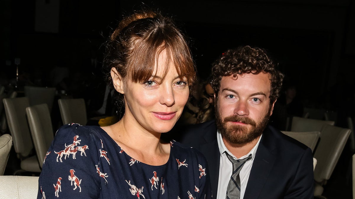 Danny Masterson sits behind wife Bijou Phillips at event