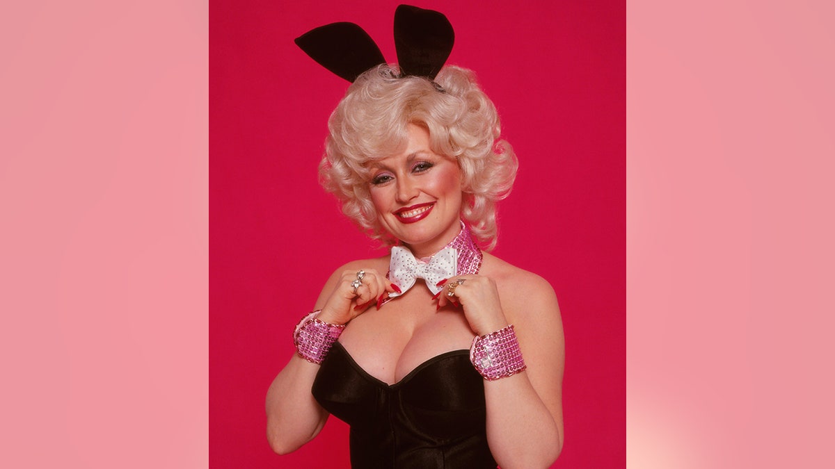 Dolly Parton poses as a playboy bunny in 1978 with a black bustier, ears and white bow tie