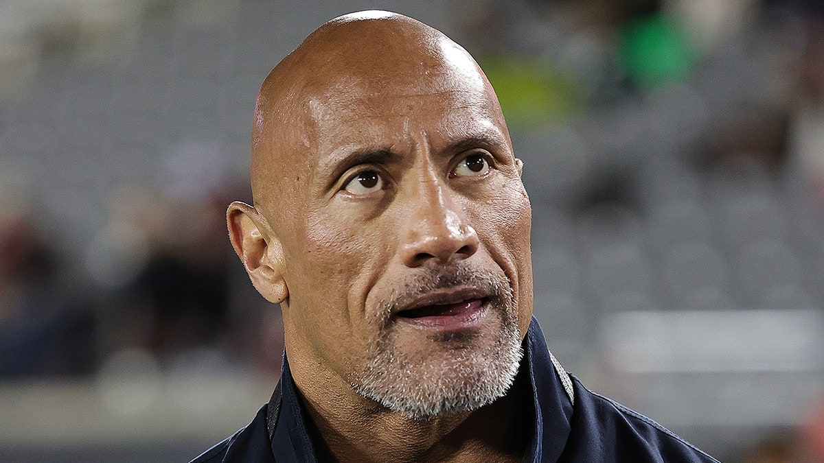 Dwayne Johnson looks up in the crowd while appearing at the Houston Roughnecks and Orlando Guardians game