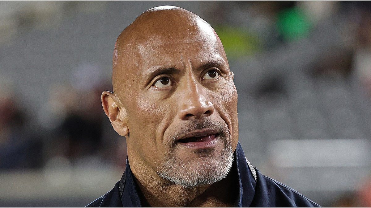 Dwayne Johnson looks up in the crowd while appearing at the Houston Roughnecks and Orlando Guardians game