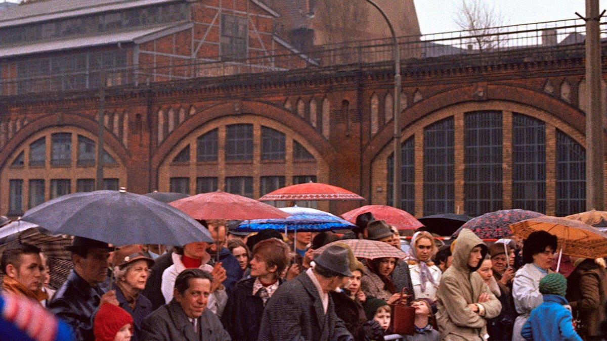 people in line with umbrellas