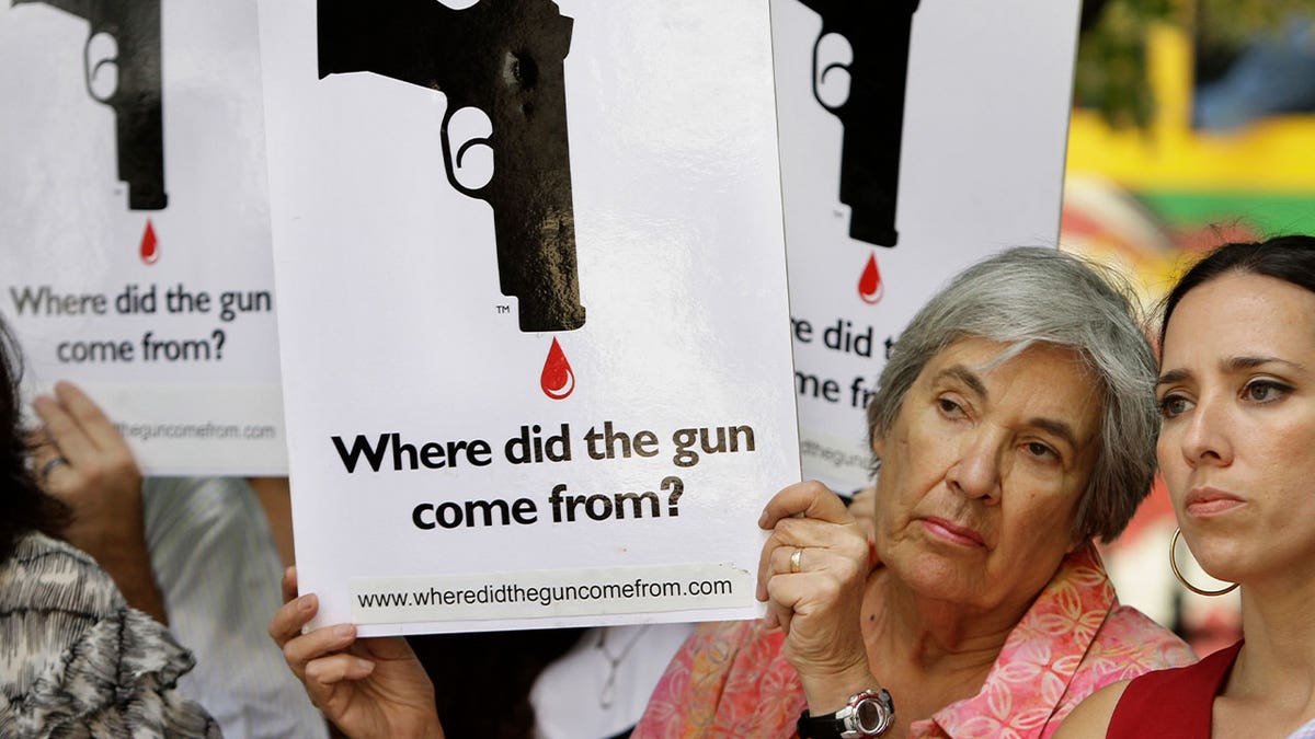 woman holds anti-gun poster