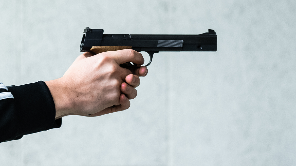 hands grasping handgun, squeezing trigger stock image