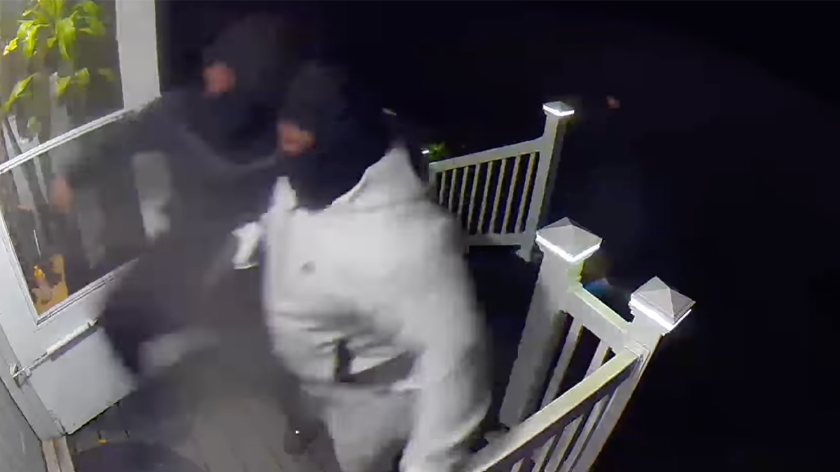 Three masked suspects kicking door