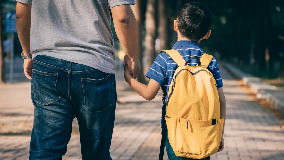 dad holds son's hand