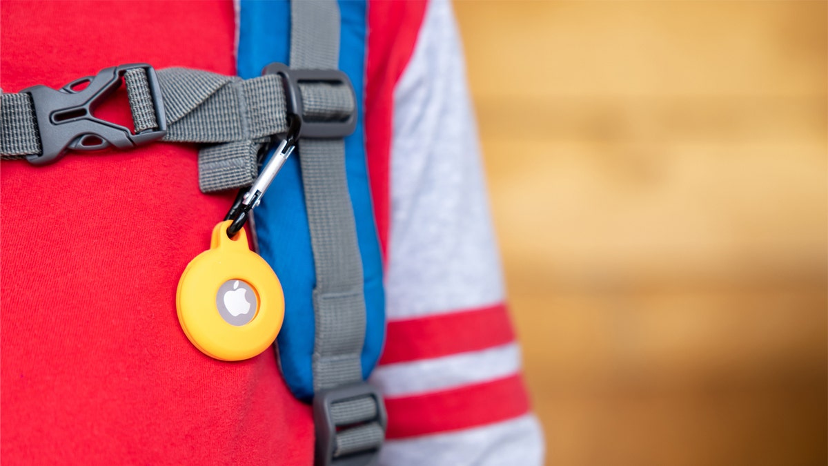 Apple AirTag clipped to child's bookbag.