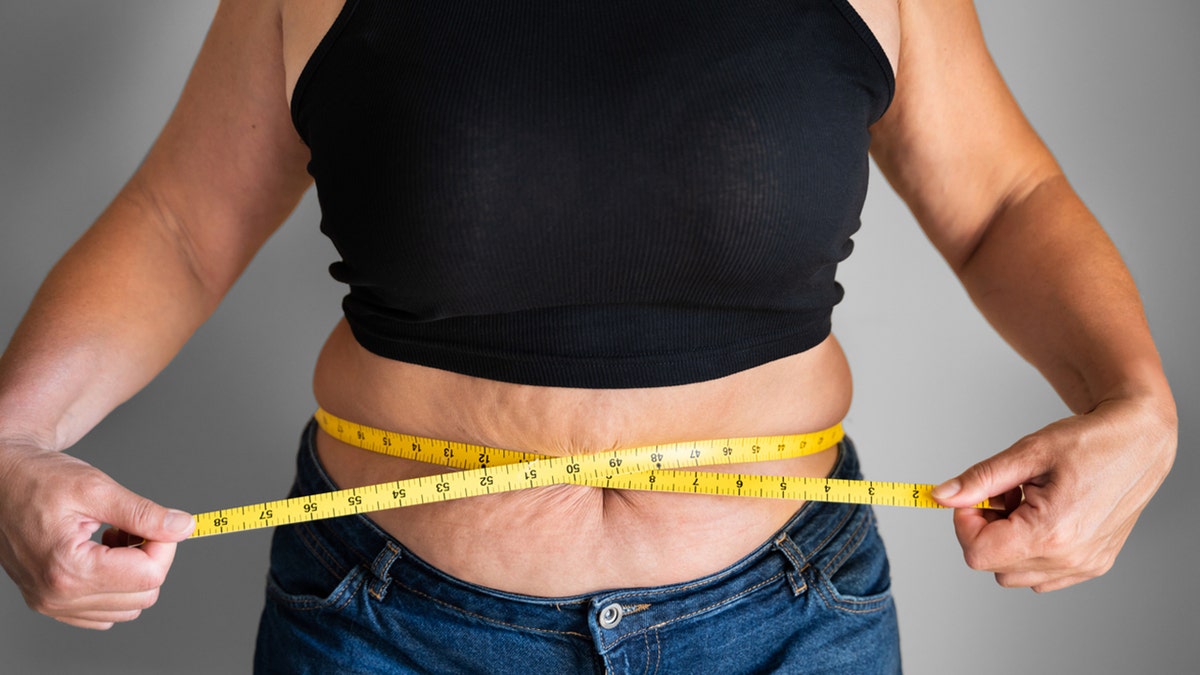 woman measures belly fat