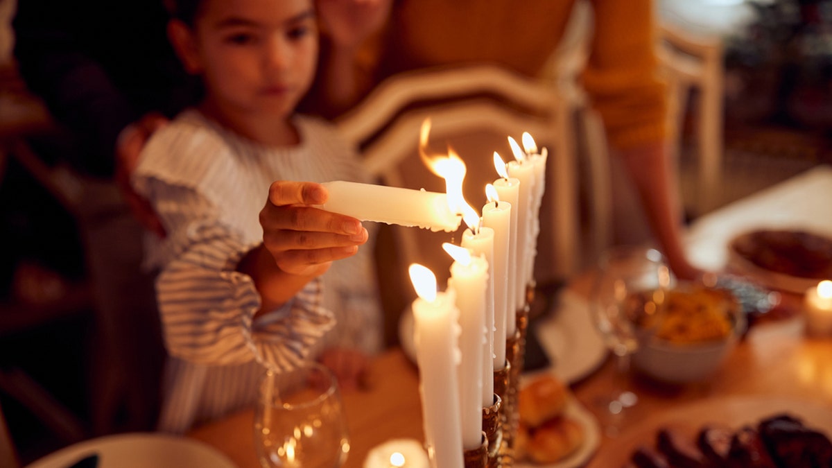 Girl lighting a menorah