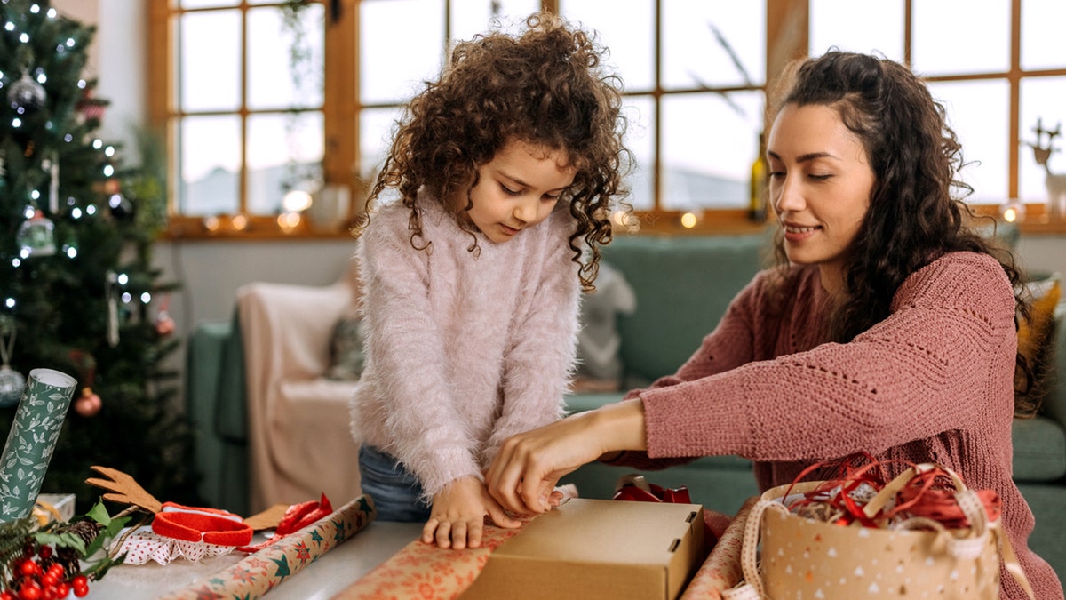 mother and daughter wrapping gift