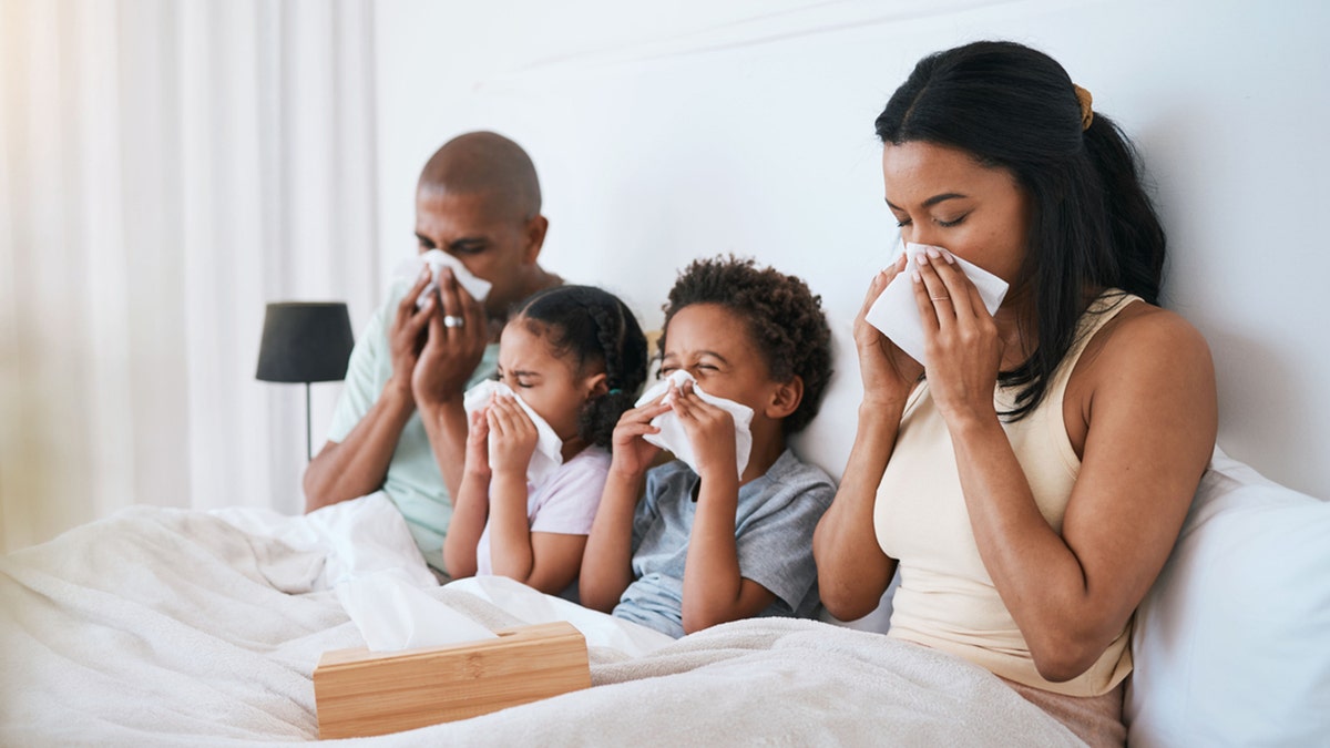 family in bed with the flu
