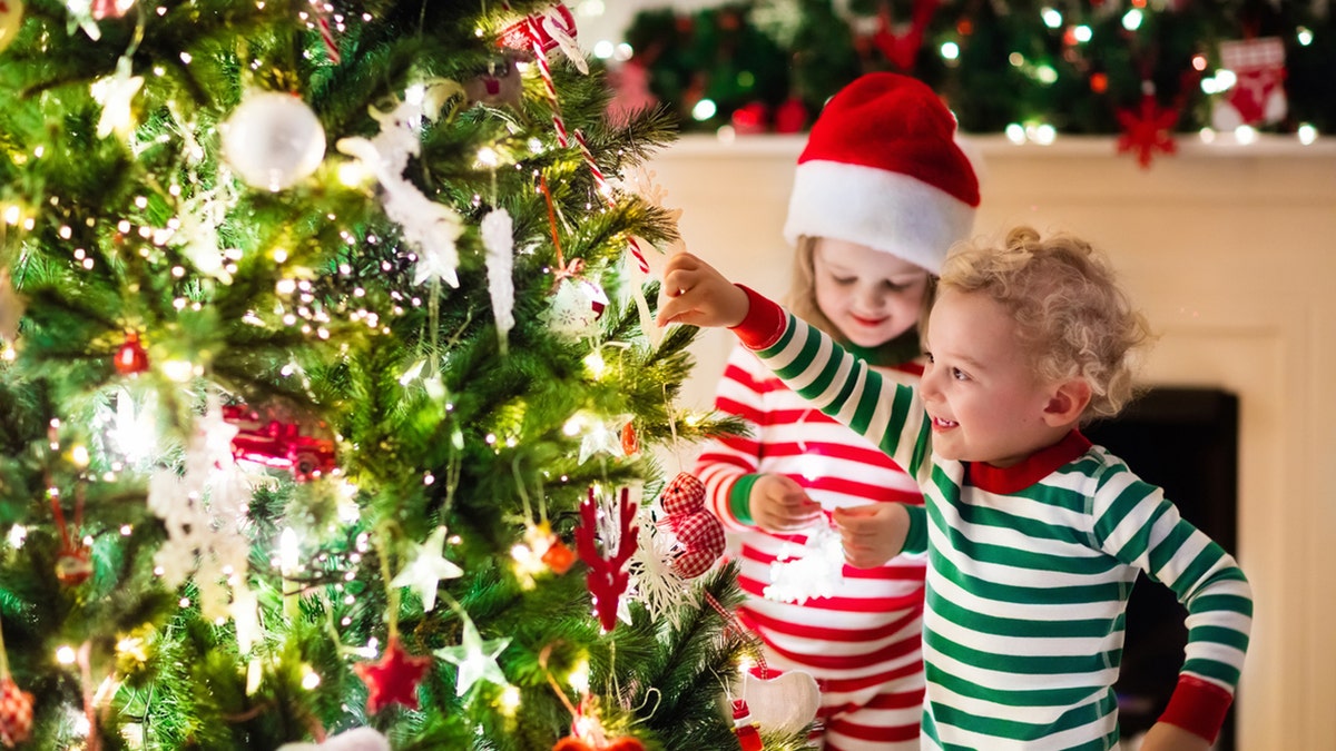 children hanging Christmas ornament