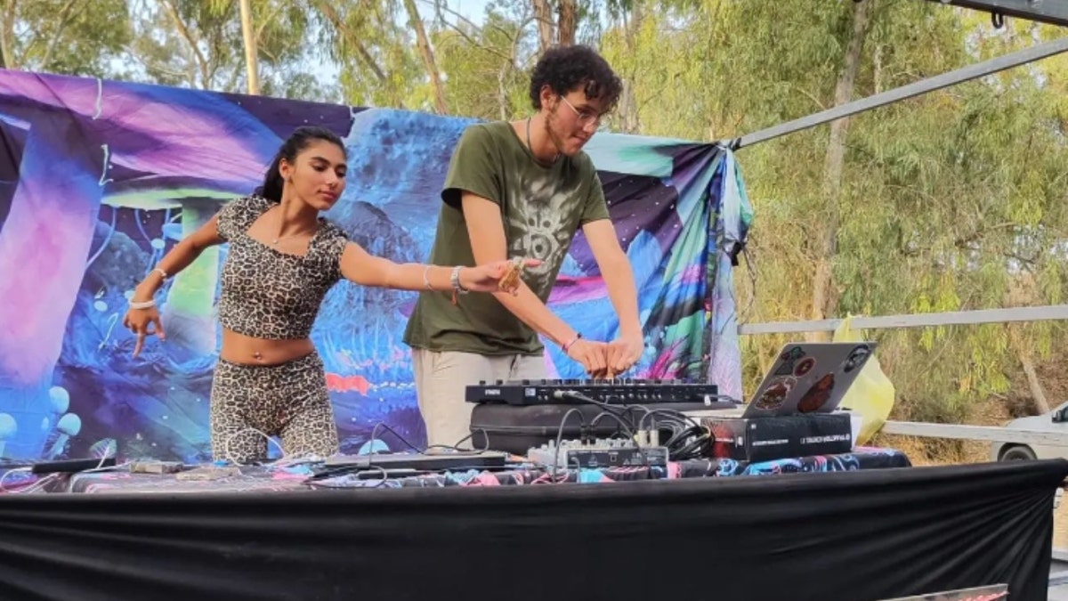 Laor Abramov (right) DJs next to a woman dancing (left)