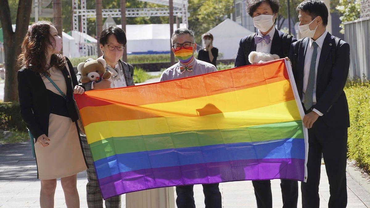 people hold rainbow flag