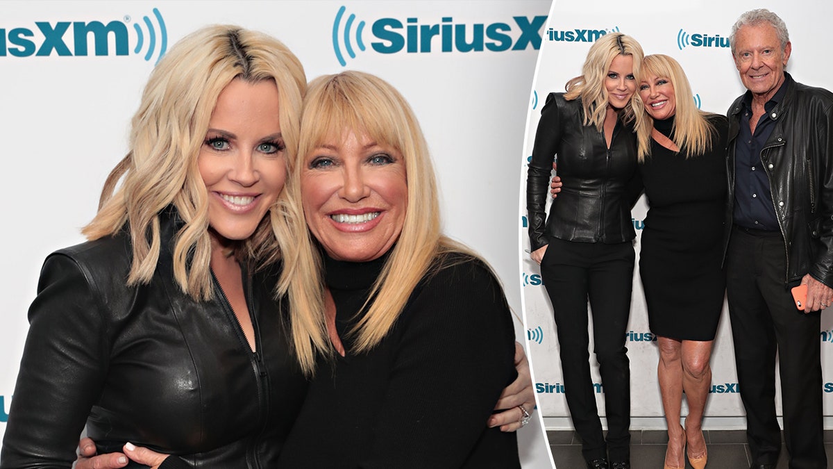 Jenny McCarthy e Suzanne Somers entrambe in nero sorridono e si abbracciano divise. Suzanne Somers si appoggia a Jenny McCarthy mentre posa per una foto anche con il marito Alan